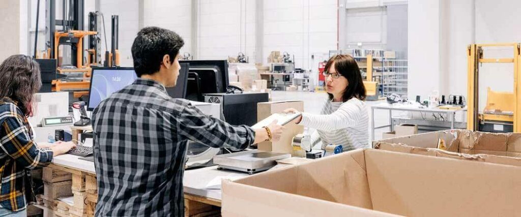 A warehouse worker handing paperwork to a customer