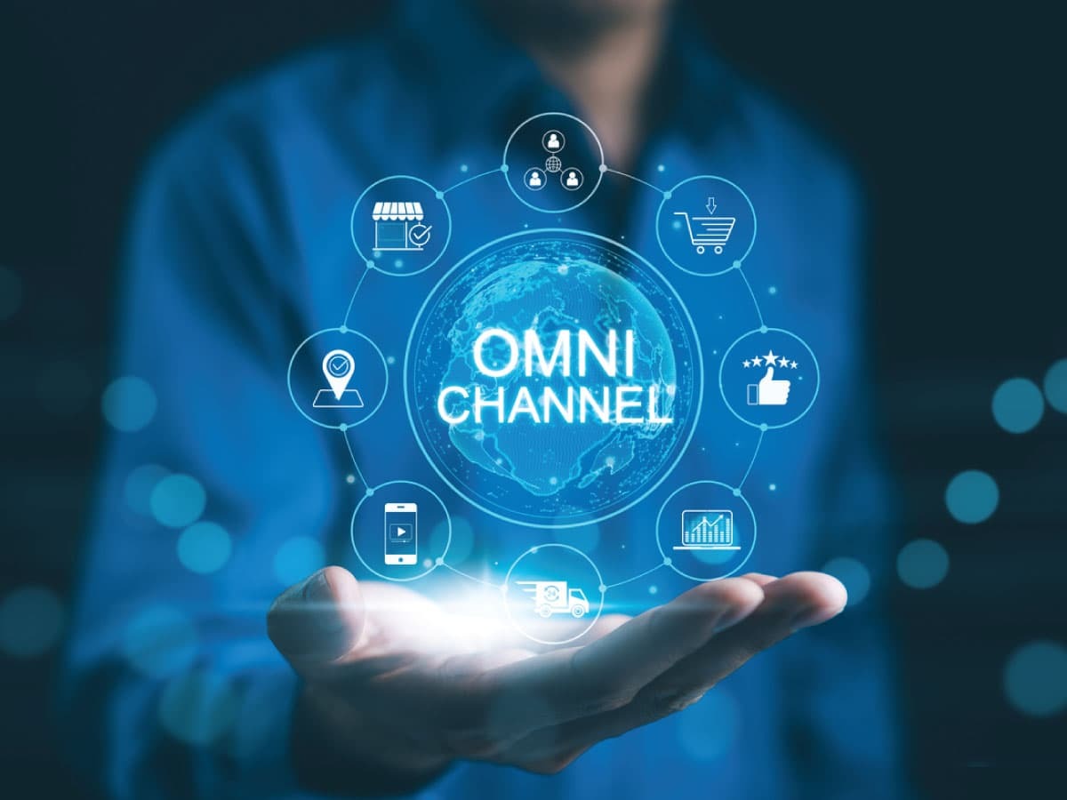 In the palm of someone's hand, a digitized circle representing various marketplaces surround the word omnichannel.